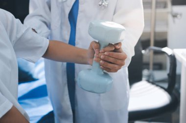 Tanımlanamayan fiziksel terapi sırasında mavi el ağırlığı kullanır