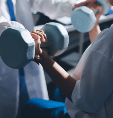 Tanımlanamayan fiziksel terapi sırasında mavi el ağırlığı kullanır