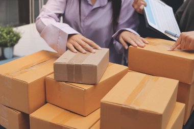 Küçük işletmeler kurma portresi KOBİ sahipleri ve iki Asyalı kadın online siparişleri kontrol ediyor. Ev işlerinde çalışan kutucuklarla çalışan ürünleri satıyorlar.