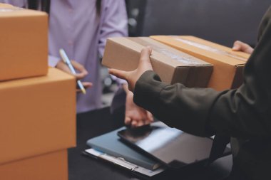 Küçük işletmeler kurma portresi KOBİ sahipleri ve iki Asyalı kadın online siparişleri kontrol ediyor. Ev işlerinde çalışan kutucuklarla çalışan ürünleri satıyorlar.