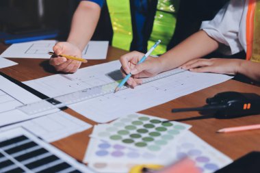 Endüstriyel mühendislerden oluşan bir ekip, fabrikadaki masada bulunan makine planlarını analiz ediyor. Fabrikada ya da üretim tesisinde çalışıyorum..
