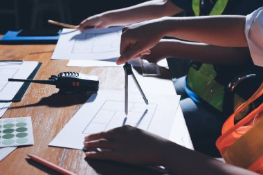 Endüstriyel mühendislerden oluşan bir ekip, fabrikadaki masada bulunan makine planlarını analiz ediyor. Fabrikada ya da üretim tesisinde çalışıyorum..