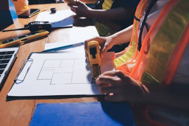 Endüstriyel mühendislerden oluşan bir ekip, fabrikadaki masada bulunan makine planlarını analiz ediyor. Fabrikada ya da üretim tesisinde çalışıyorum..