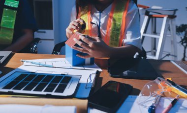 Endüstriyel mühendislerden oluşan bir ekip, fabrikadaki masada bulunan makine planlarını analiz ediyor. Fabrikada ya da üretim tesisinde çalışıyorum..