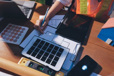 Endüstriyel mühendislerden oluşan bir ekip, fabrikadaki masada bulunan makine planlarını analiz ediyor. Fabrikada ya da üretim tesisinde çalışıyorum..