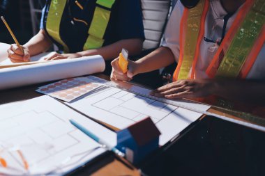 Endüstriyel mühendislerden oluşan bir ekip, fabrikadaki masada bulunan makine planlarını analiz ediyor. Fabrikada ya da üretim tesisinde çalışıyorum..
