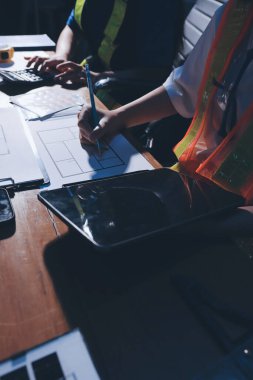 Endüstriyel mühendislerden oluşan bir ekip, fabrikadaki masada bulunan makine planlarını analiz ediyor. Fabrikada ya da üretim tesisinde çalışıyorum..