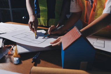 Endüstriyel mühendislerden oluşan bir ekip, fabrikadaki masada bulunan makine planlarını analiz ediyor. Fabrikada ya da üretim tesisinde çalışıyorum..