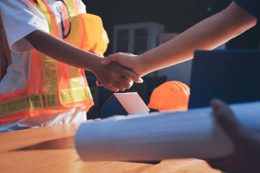 Endüstriyel mühendislerden oluşan bir ekip, fabrikadaki masada bulunan makine planlarını analiz ediyor. Fabrikada ya da üretim tesisinde çalışıyorum..