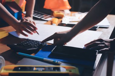 Endüstriyel mühendislerden oluşan bir ekip, fabrikadaki masada bulunan makine planlarını analiz ediyor. Fabrikada ya da üretim tesisinde çalışıyorum..