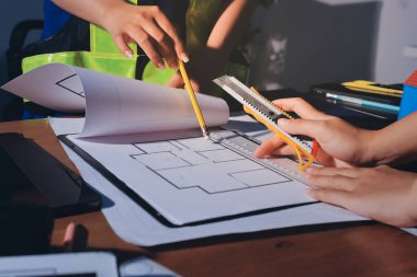 Endüstriyel mühendislerden oluşan bir ekip, fabrikadaki masada bulunan makine planlarını analiz ediyor. Fabrikada ya da üretim tesisinde çalışıyorum..