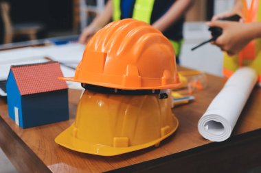 Endüstriyel mühendislerden oluşan bir ekip, fabrikadaki masada bulunan makine planlarını analiz ediyor. Fabrikada ya da üretim tesisinde çalışıyorum..