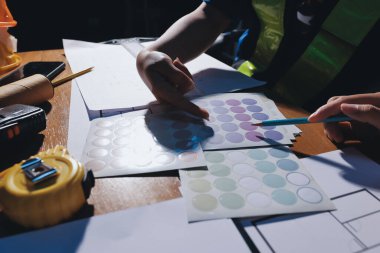 Endüstriyel mühendislerden oluşan bir ekip, fabrikadaki masada bulunan makine planlarını analiz ediyor. Fabrikada ya da üretim tesisinde çalışıyorum..