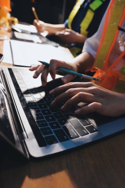 Endüstriyel mühendislerden oluşan bir ekip, fabrikadaki masada bulunan makine planlarını analiz ediyor. Fabrikada ya da üretim tesisinde çalışıyorum..