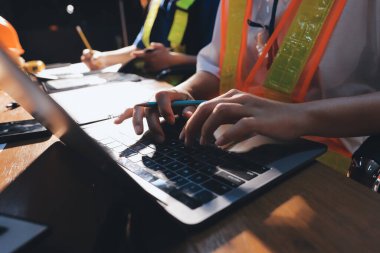 Endüstriyel mühendislerden oluşan bir ekip, fabrikadaki masada bulunan makine planlarını analiz ediyor. Fabrikada ya da üretim tesisinde çalışıyorum..