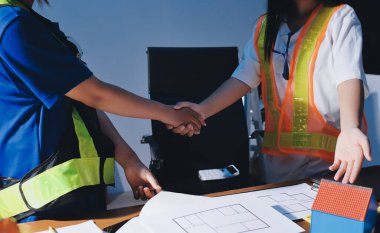 Endüstriyel mühendislerden oluşan bir ekip, fabrikadaki masada bulunan makine planlarını analiz ediyor. Fabrikada ya da üretim tesisinde çalışıyorum..