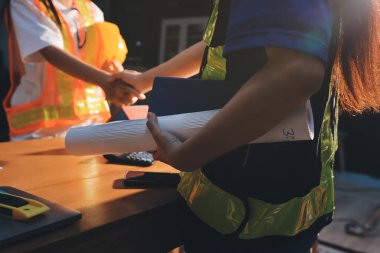 Endüstriyel mühendislerden oluşan bir ekip, fabrikadaki masada bulunan makine planlarını analiz ediyor. Fabrikada ya da üretim tesisinde çalışıyorum..