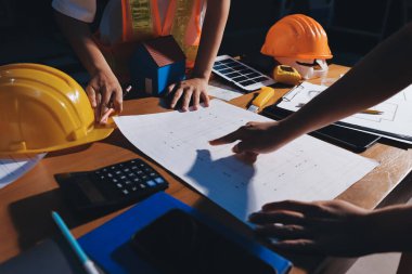 Endüstriyel mühendislerden oluşan bir ekip, fabrikadaki masada bulunan makine planlarını analiz ediyor. Fabrikada ya da üretim tesisinde çalışıyorum..