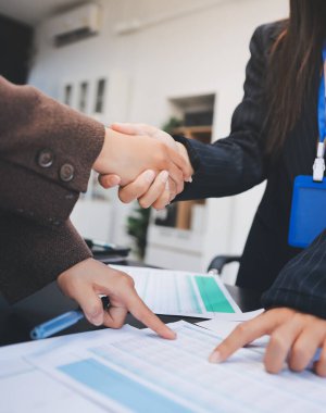 İş adamları ofiste el sıkışıyor. Kontratı imzaladıktan sonra iki iş ortağı el sıkışıyor..