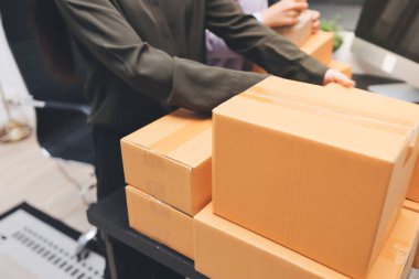 Küçük işletmeler kurma portresi KOBİ sahipleri ve iki Asyalı kadın online siparişleri kontrol ediyor. Ev işlerinde çalışan kutucuklarla çalışan ürünleri satıyorlar.