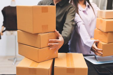 Küçük işletmeler kurma portresi KOBİ sahipleri ve iki Asyalı kadın online siparişleri kontrol ediyor. Ev işlerinde çalışan kutucuklarla çalışan ürünleri satıyorlar.