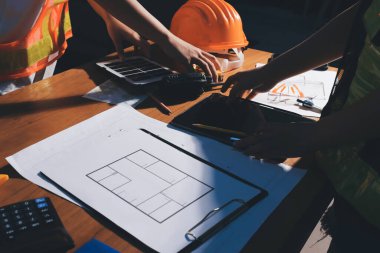 Endüstriyel mühendislerden oluşan bir ekip, fabrikadaki masada bulunan makine planlarını analiz ediyor. Fabrikada ya da üretim tesisinde çalışıyorum..