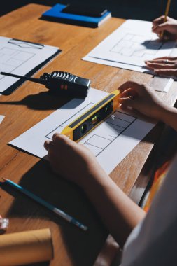 Endüstriyel mühendislerden oluşan bir ekip, fabrikadaki masada bulunan makine planlarını analiz ediyor. Fabrikada ya da üretim tesisinde çalışıyorum..