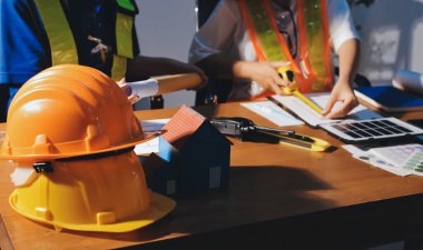 Endüstriyel mühendislerden oluşan bir ekip, fabrikadaki masada bulunan makine planlarını analiz ediyor. Fabrikada ya da üretim tesisinde çalışıyorum..