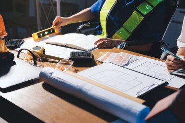 Endüstriyel mühendislerden oluşan bir ekip, fabrikadaki masada bulunan makine planlarını analiz ediyor. Fabrikada ya da üretim tesisinde çalışıyorum..