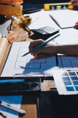 Endüstriyel mühendislerden oluşan bir ekip, fabrikadaki masada bulunan makine planlarını analiz ediyor. Fabrikada ya da üretim tesisinde çalışıyorum..