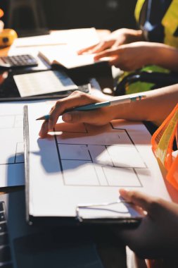 Endüstriyel mühendislerden oluşan bir ekip, fabrikadaki masada bulunan makine planlarını analiz ediyor. Fabrikada ya da üretim tesisinde çalışıyorum..