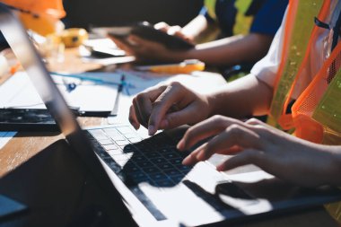 Endüstriyel mühendislerden oluşan bir ekip, fabrikadaki masada bulunan makine planlarını analiz ediyor. Fabrikada ya da üretim tesisinde çalışıyorum..