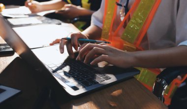 Endüstriyel mühendislerden oluşan bir ekip, fabrikadaki masada bulunan makine planlarını analiz ediyor. Fabrikada ya da üretim tesisinde çalışıyorum..
