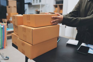 Küçük işletmeler kurma portresi KOBİ sahipleri ve iki Asyalı kadın online siparişleri kontrol ediyor. Ev işlerinde çalışan kutucuklarla çalışan ürünleri satıyorlar.