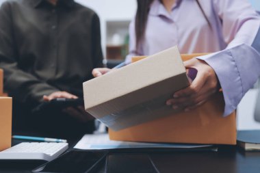 Küçük işletmeler kurma portresi KOBİ sahipleri ve iki Asyalı kadın online siparişleri kontrol ediyor. Ev işlerinde çalışan kutucuklarla çalışan ürünleri satıyorlar.