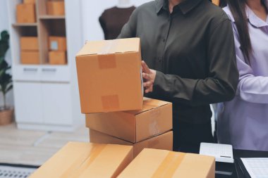 Küçük işletmeler kurma portresi KOBİ sahipleri ve iki Asyalı kadın online siparişleri kontrol ediyor. Ev işlerinde çalışan kutucuklarla çalışan ürünleri satıyorlar.