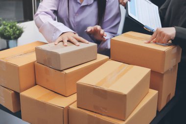 Küçük işletmeler kurma portresi KOBİ sahipleri ve iki Asyalı kadın online siparişleri kontrol ediyor. Ev işlerinde çalışan kutucuklarla çalışan ürünleri satıyorlar.