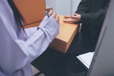 Küçük işletmeler kurma portresi KOBİ sahipleri ve iki Asyalı kadın online siparişleri kontrol ediyor. Ev işlerinde çalışan kutucuklarla çalışan ürünleri satıyorlar.