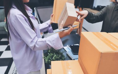 Küçük işletmeler kurma portresi KOBİ sahipleri ve iki Asyalı kadın online siparişleri kontrol ediyor. Ev işlerinde çalışan kutucuklarla çalışan ürünleri satıyorlar.