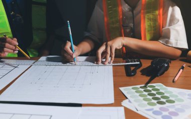 Endüstriyel mühendislerden oluşan bir ekip, fabrikadaki masada bulunan makine planlarını analiz ediyor. Fabrikada ya da üretim tesisinde çalışıyorum..