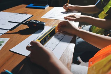 Endüstriyel mühendislerden oluşan bir ekip, fabrikadaki masada bulunan makine planlarını analiz ediyor. Fabrikada ya da üretim tesisinde çalışıyorum..