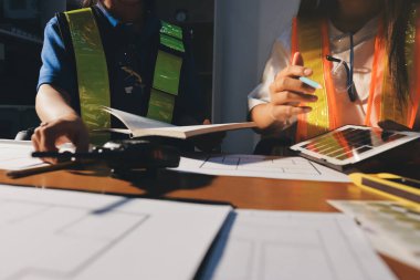 Endüstriyel mühendislerden oluşan bir ekip, fabrikadaki masada bulunan makine planlarını analiz ediyor. Fabrikada ya da üretim tesisinde çalışıyorum..