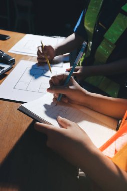 Endüstriyel mühendislerden oluşan bir ekip, fabrikadaki masada bulunan makine planlarını analiz ediyor. Fabrikada ya da üretim tesisinde çalışıyorum..