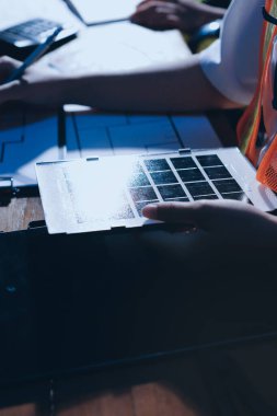 Endüstriyel mühendislerden oluşan bir ekip, fabrikadaki masada bulunan makine planlarını analiz ediyor. Fabrikada ya da üretim tesisinde çalışıyorum..