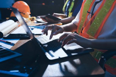 Endüstriyel mühendislerden oluşan bir ekip, fabrikadaki masada bulunan makine planlarını analiz ediyor. Fabrikada ya da üretim tesisinde çalışıyorum..