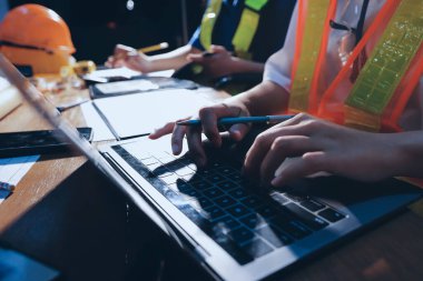 Endüstriyel mühendislerden oluşan bir ekip, fabrikadaki masada bulunan makine planlarını analiz ediyor. Fabrikada ya da üretim tesisinde çalışıyorum..