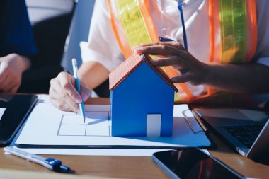 Endüstriyel mühendislerden oluşan bir ekip, fabrikadaki masada bulunan makine planlarını analiz ediyor. Fabrikada ya da üretim tesisinde çalışıyorum..