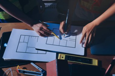 Endüstriyel mühendislerden oluşan bir ekip, fabrikadaki masada bulunan makine planlarını analiz ediyor. Fabrikada ya da üretim tesisinde çalışıyorum..