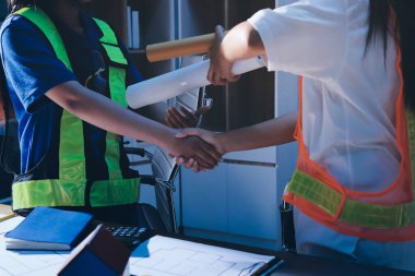 Endüstriyel mühendislerden oluşan bir ekip, fabrikadaki masada bulunan makine planlarını analiz ediyor. Fabrikada ya da üretim tesisinde çalışıyorum..