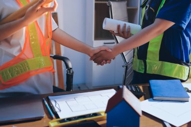 Endüstriyel mühendislerden oluşan bir ekip, fabrikadaki masada bulunan makine planlarını analiz ediyor. Fabrikada ya da üretim tesisinde çalışıyorum..